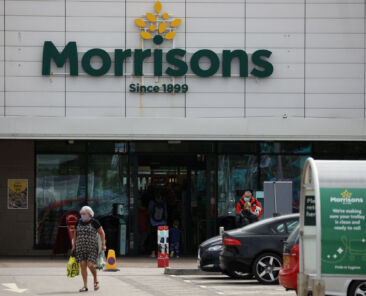 FILE PHOTO: A customer carries a shopping bag outside a Morrisons supermarket in New Brighton, Britain, July 5, 2021. REUTERS/Phil Noble/File Photo